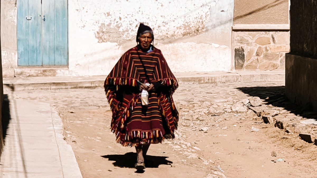 Men in Tarabuco often wear black helmet-like headwear with ornaments, including striped ponchos.