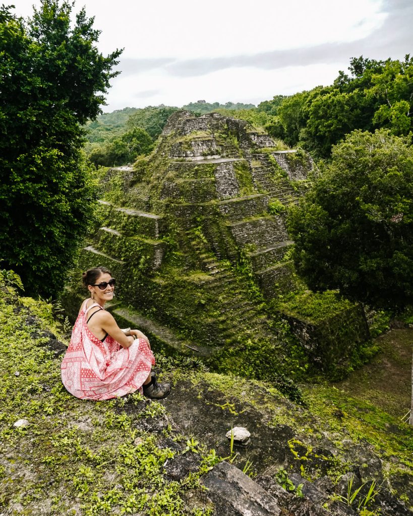 Deborah op noordelijke acropolis met uitzicht op tempel 216 in Yaxha