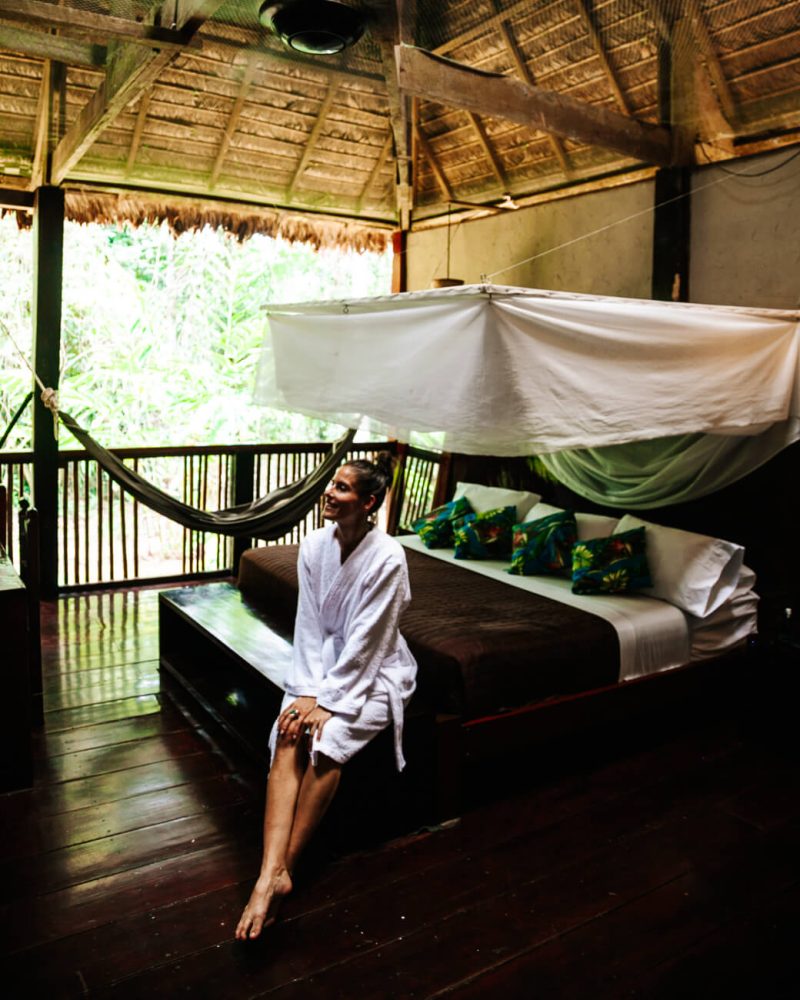 Deborah op bedrand in deluxe kamer bij Posada Amazonas - jungle lodge Tambopata Peru van Rainforest Expeditions