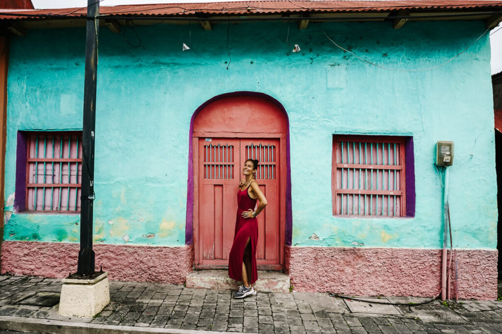 vrouw voor gekleurde huisjes in Flores Guatemala