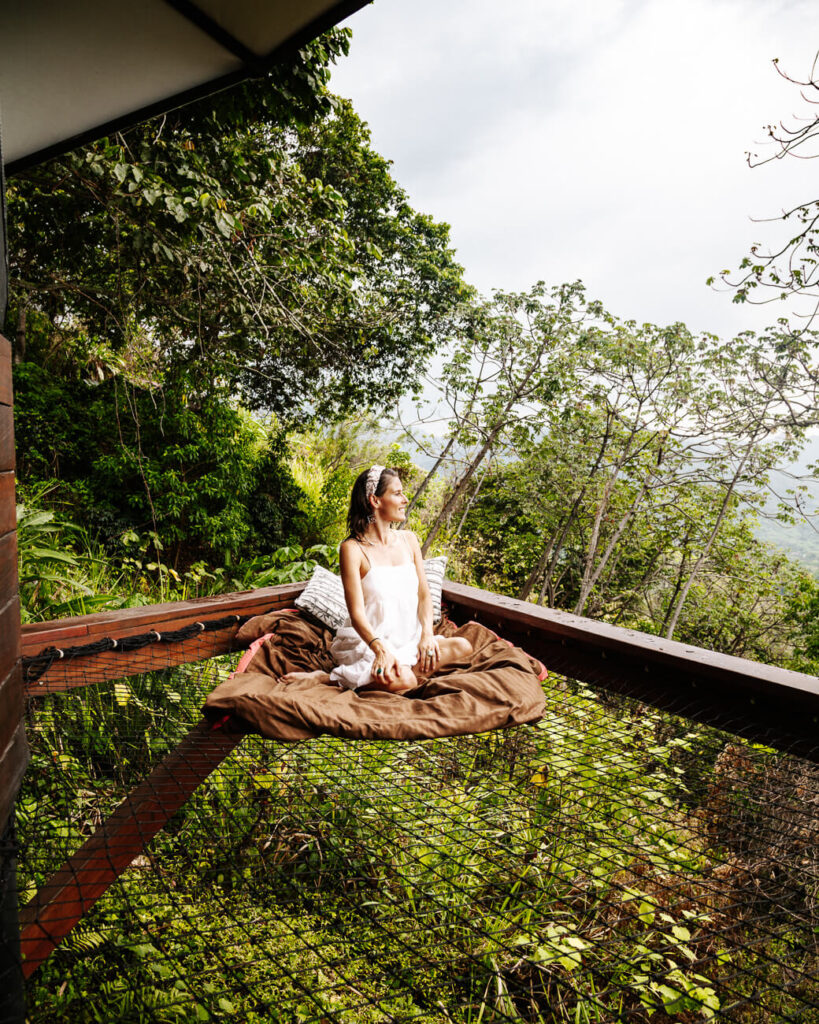 Deborah in hangmat genietend van uitzicht op Santa Marta en kust vanaf Trekker Glamping in Colombia